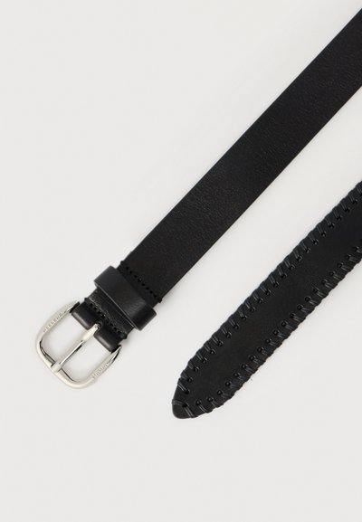 Μαύρη δερμάτινη ζώνη με λεία επιφάνεια, που διαθέτει ασημένια ορθογώνια αγκράφα και διακοσμητικό ράψιμο κατά μήκος μιας άκρης.