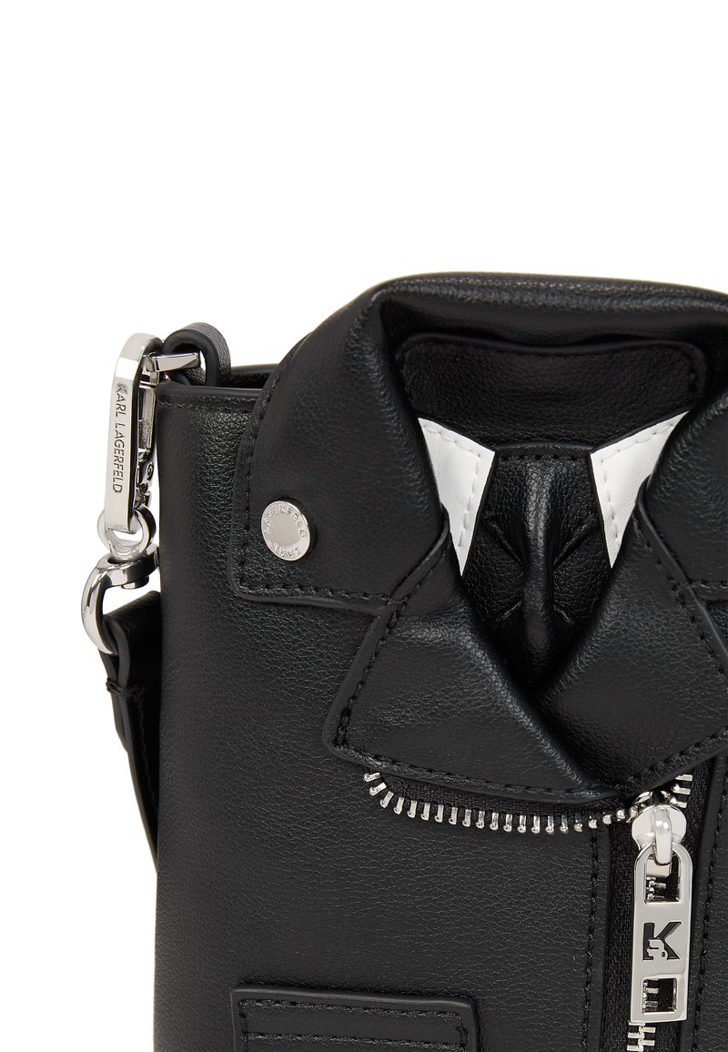 Schwarze Lederhandtasche mit einem Reißverschluss, strukturiertem Finish, silbernem Zubehör und einem Kragen-Designdetail. Innenseite in Weiß.
