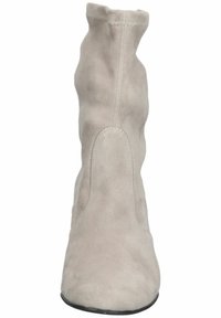 Bottine en daim beige clair avec une tige douce et légèrement froissée et un bout arrondi, vue de face.