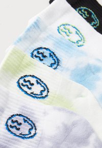 Calcetines coloridos con patrones de tie-dye en azul, verde y púrpura, con logotipos bordados en negro y azul en cada calcetín.