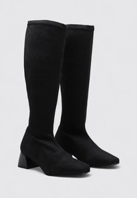 Black knee-high boots made of soft suede, featuring a pointed toe design and a block heel. Smooth texture with a sleek silhouette.