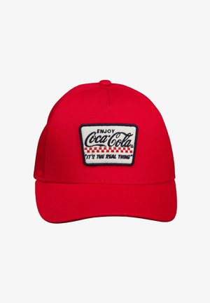 Casquette de baseball rouge avec un écusson blanc portant l'inscription « Enjoy Coca-Cola » et « It's the real thing » en écriture noire cursive avec un motif à damier rouge.