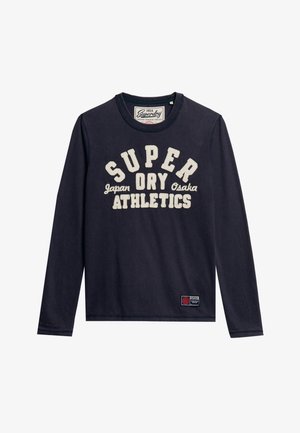 Marineblauwe longsleeve t-shirt van katoen met een ronde hals. Kenmerkt zich door witte grafische tekst: "SUPER DRY Japan Osaka ATHLETICS," en een logo patch.