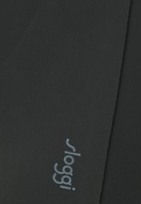 Crni rastezljivi materijal s rebrastom teksturom. Ističe se istaknutim sivim "sloggi" logotipom otisnutim horizontalno. Jednostavan, besprijekoran dizajn.