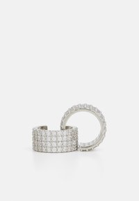 Anillos de plata que presentan una fila de piedras claras redondas dispuestas en un patrón agrupar; un anillo es más ancho con una densa cobertura de piedras, el otro es acanalado.