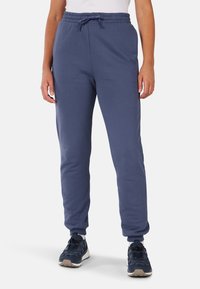 Granatowe dresy z elastycznym paskiem i sznureczkiem, elastycznymi mankietami oraz gładką fakturą. Zaprojektowane z myślą o komforcie i swobodzie ruchów.