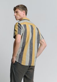 Gestreepte, korte mouw shirt in geel, grijs en zwart. Beschikt over een spread collar, gestructureerde stof en een achterste schouderpas ontwerp.