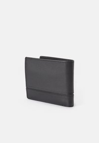 Mustast nahast rahakott, millel on sile tekstuur, sõlmitud aksessuaarid, peennelguline ristkülikukujuline kuju ja minimalistlik disain.