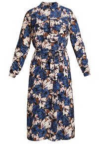 Blommig skjortklänning i blått, vitt och brunt. Har långa ärmar, krage, knäppning fram, två bröstfickor och ett bälte i midjan.