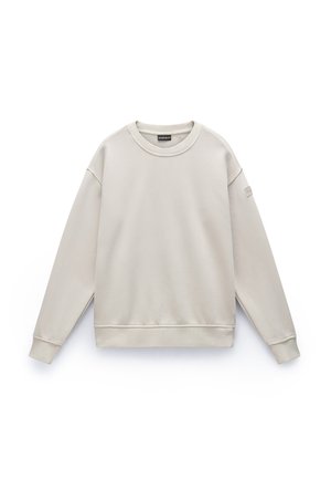 Beige sweatshirt met een ronde halslijn, lange mouwen en geribbelde manchetten. Gemaakt van zachte stof, met een klein logo-patch op de mouw.
