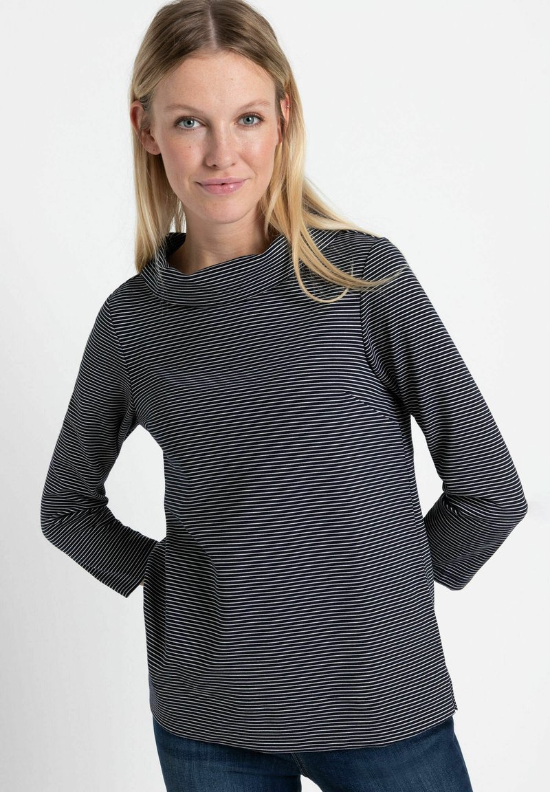 Langarmshirt in Marineblau und Weiß mit Streifen, hohem Kragen und lockerer Passform. Der Stoff wirkt weich mit einer glatten Textur und leichtem Stretch.
