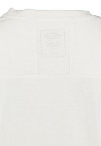 Witte katoenen t-shirt met een label op de achterkant, met een zachte, gemarmerde structuur en een eenvoudig, onbeschilderd ontwerp.