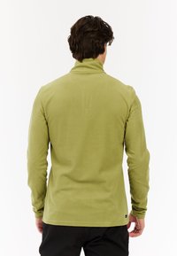 Pullover in pile verde con colletto alto, maniche lunghe e texture morbida. Presenta un'etichetta piccola sul lato sinistro in basso.