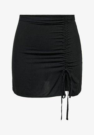 Melnā mini svārku izgatavota no elastīga auduma, ar sānu rāvējslēdzējiem un regulējamām saitēm apakšā, lai mainītu garumu. Gluda tekstūra.