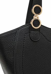 Schwarze strukturierte Ledertasche mit goldenen runden Hardwareakzenten. Sie verfügt über gestickte Details und eine glatte Oberfläche.