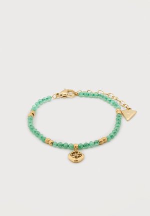 Bracelet avec de petites perles rondes vertes, des perles intercalaires en or, un pendentif en or avec un motif ajouré, et une chaîne de fermeture ajustable en or.