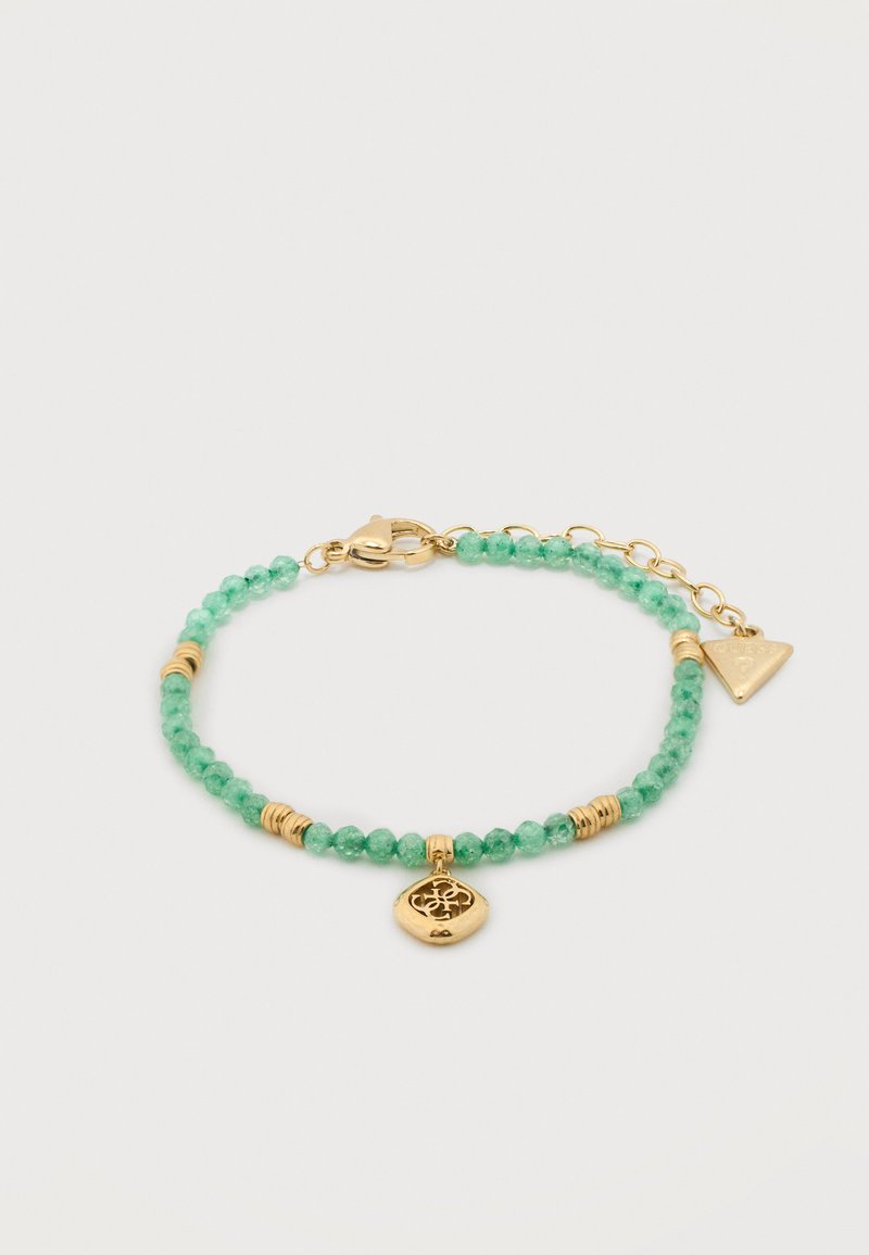 Βραχιόλι με μικρές στρογγυλές πράσινες χάντρες, χρυσές χάντρες διαχωρισμού, ένα χρυσό φυλαχτό με σχέδιο σε κοπή και ένα ρυθμιζόμενο κούμπωμα αλυσίδας από χρυσό.