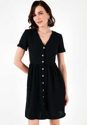 Black button-up dress with short sleeves, featuring a V-neck, gathered waist, and large metallic buttons along the front. Smooth texture.