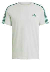T-shirt bianco in cotone a maniche corte, con accenti verdi a tre strisce sulle spalle e un piccolo logo Adidas verde sul petto.