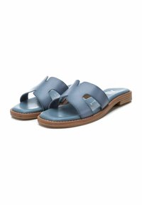 Sandalias deslizantes de cuero azul con dos correas anchas, textura suave, punta redondeada y suela de madera plana. Detalle de costura sutil a lo largo del borde.