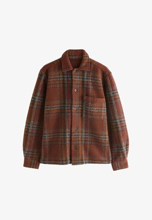 Hnědá flanelová košile s límcem, ve vzoru kostky; obsahuje oranžové, modré a zelené pruhy, přední kapsu a knoflíkové zapínání.