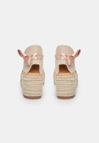 Bēša espadrille papēžu kurpes ar austām tekstilajām virsām un rozā satīna bantīm aizmugurē, ar pītajām jutu platformām un koka zoli.