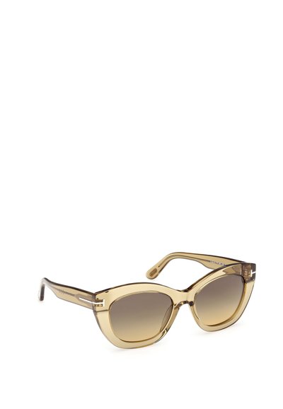 Sluneční brýle ve stylu kočičích očí s průsvitnými světle hnědými rámy. Gradientní hnědé čočky a jemné detaily na stranicích zvýrazňují design.