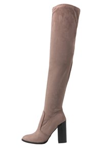 Bota de ante beige hasta la rodilla con una superficie texturizada, tacón cuadrado y un diseño ajustado y elegante. Presenta una punta redondeada y sin herrajes visibles.