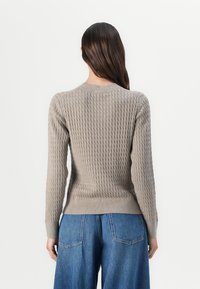 Lichtgrijze pullover trui met een gestructureerd ribbelpatroon, lange mouwen en een ronde halslijn. Draag het met hoge taille blauwe jeans.