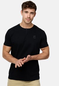 Crni kratki rukav Henley majica od pamuka, s okruglim izrezom, dvostrukim dugmetom i malim logotipom na prsima.