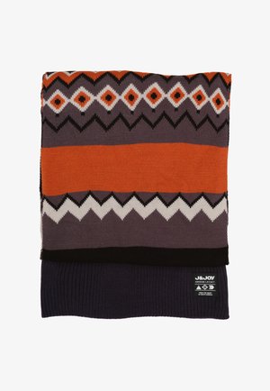 Gebreide sjaal met geometrische patronen in oranje, wit en zwart tegen een paarse achtergrond, met een zwarte ribbelrand en logo label.