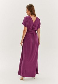 Dlhé fialové šaty s krátkymi rukávmi, V-ružkom a zberaným pásom. Vyrobené z hladkej, jemnej látky s splývavým dizajnom.