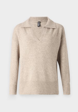 Beige neulepaita, jossa on V-pääntie ja ribattu kaulus. Siinä on pitkät hihat ja ribattu helma, valmistettu pehmeästä, teksturoidusta materiaalista.