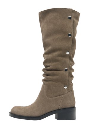 Stivale in camoscio taupe fino al ginocchio con tacco basso a blocco nero e cinque bottoni automatici color argento lungo il polpaccio esterno.