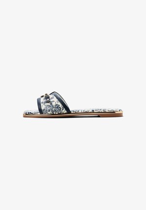 Sandalia plana con tiras de estampado floral en azul marino y blanco y suela acolchada, con un pequeño detalle de hebilla metálica.