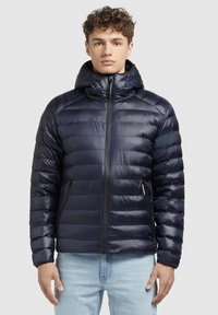 Mornarskoplava pufasta jakna od sjajnog materijala s kapuljačom, s patentnim zatvaračem i dva prednja džepa, dizajnirana s quilted sekcijama.
