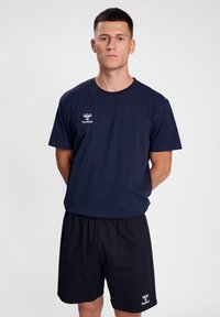Marineblå bomull T-skjorte med rund hals og korte ermer, kombinert med svarte shorts med brodert logo på kanten.