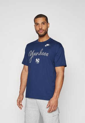 Navy blue cotton t-shirt featuring "Yankees" in silver script, Nike logo on the chest, short sleeves, and a crew neckline.