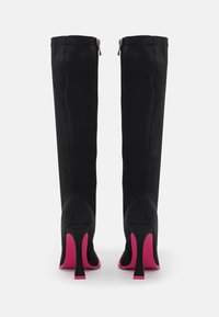 Bottes noires hauteur genou avec un design élégant, talons aiguilles roses foncés, et fermetures éclair latérales argentées. Fabriquées en tissu lisse avec une coupe ajustée.