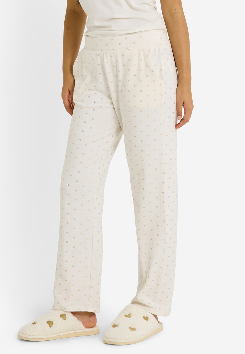 Pantalones ligeros de color crema con lunares dorados. Fabricados con una tela suave, cuentan con una cinturilla elástica y bolsillos laterales. Ajuste casual.