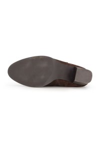 Chaussure à talons hauts en daim marron avec une semelle en caoutchouc lisse et un talon légèrement texturé, présentant un bout rond et des éléments de design minimaux.