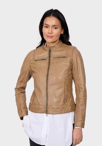 Veste en cuir tan avec col montant, fermeture éclair à l'avant et deux poches zippées. Texture lisse et design ajusté.