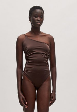 Maillot de bain marron à une épaule avec un design ajusté, texture froncée et jambes à découpe haute. Fabriqué en matériau lisse et extensible.