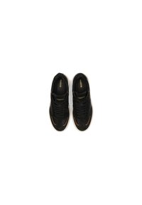 Sneaker nere in suede con suola in gomma bianca liscia, dotate di lacci neri e sottili accenti bronzati lungo i bordi.