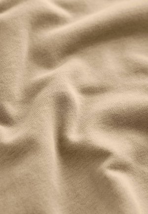 Tejido de algodón beige con una textura suave y lisa, presentado en suaves pliegues, mostrando un patrón de punto fino y un brillo sutil.