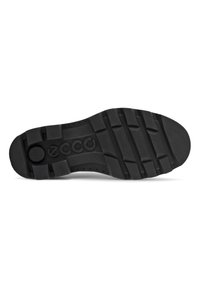Semelle de chaussure en caoutchouc noir avec des rainures profondes, comprenant un logo central et de multiples cannelures pour l'adhérence et la flexibilité. Texture lisse sans ornements.