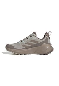 Light gray athletic shoes with a textured design and dark gray accents. Features a layered sole for grip and support, with a pull tab on the heel.