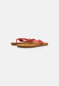 Red floral-patterned flip-flops with a textured strap and a smooth brown footbed, featuring a low-profile design and durable sole.