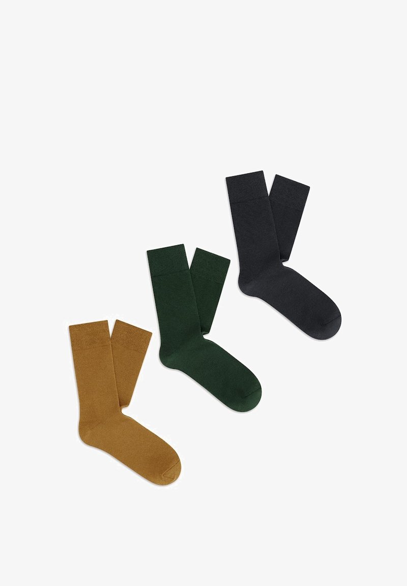 Trzy pary skarpetek: musztardowo-żółte, ciemnozielone i w kolorze węgla. Każda para charakteryzuje się gładką, dzianinową teksturą oraz standardową długością do kostek.
