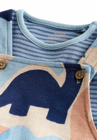 Blauw en beige peutertop met een dinosaurussenprint, met een ronde hals, gestreepte binnenlaag en houten knoopaccenten. Zachte textuur.